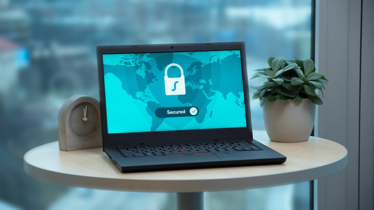 A laptop on a desk. The word “Secured” displayed on the screen. The importance of security.